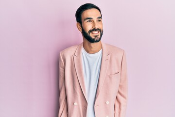 Obraz premium Young hispanic man wearing business jacket looking away to side with smile on face, natural expression. laughing confident.