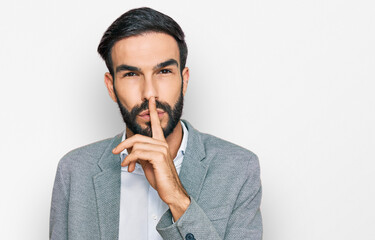 Young hispanic man wearing business clothes asking to be quiet with finger on lips. silence and secret concept.