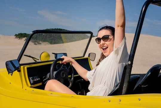 Happy woman driving on sand dunes - Powered by Adobe