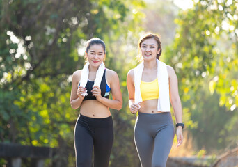 Fototapeta premium athletics couple woman having fun and taking a break after jogging or exercising together in public park