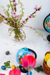 Easter eggs and globe on a white wooden background