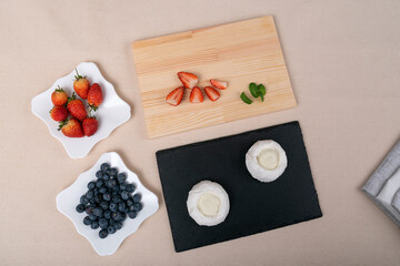 Ingredients for Pavlova cake: strawberries, blueberries and meringue. Top view.