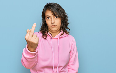Young hispanic woman wearing casual sweatshirt showing middle finger, impolite and rude fuck off...