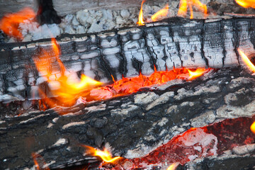Glowing embers in hot red color, abstract background. The hot embers of burning wood log fire....