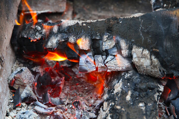 Glowing embers in hot red color, abstract background. The hot embers of burning wood log fire....