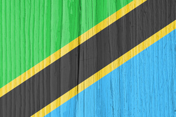 The flag of Tanzania on dry wooden surface, cracked with age. Background, wallpaper or backdrop with Tanzanian national symbol