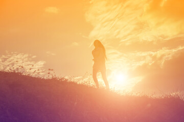 Fototapeta na wymiar Silhouette of woman praying over beautiful sky background