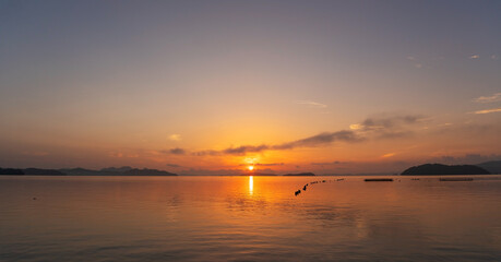 Obraz premium Beautiful sunset or sunrise with dramatic colorful sky clouds over calm sea and reflection in water surface tropical island Amazing nature view and light of nature