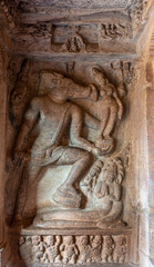 Fototapeta na wymiar Badami, Karnataka, India - November 7, 2013: Cave temples above Agasthya Lake. Brown stone sculpture featuring Vishnu as Varaha rescuing Earth as Bhudevi.