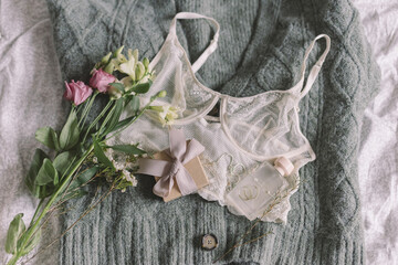 Happy Women's day. Stylish gift, jewelry, perfume, lingerie and spring flowers on sweater.Soft image