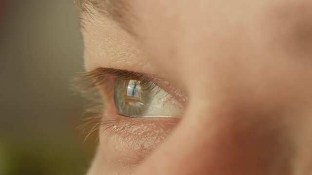 Light gray eyes of a young man, looking away, close-up