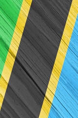The flag of Tanzania on dry wooden surface, cracked with age. Vertical background, wallpaper or...