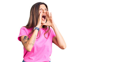 Beautiful caucasian woman wearing casual clothes shouting angry out loud with hands over mouth
