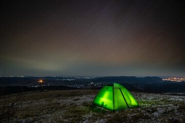 Tent on the trails of the stars in winter on the mountain