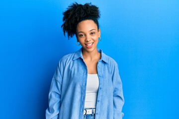 Young african american girl wearing casual clothes winking looking at the camera with sexy...