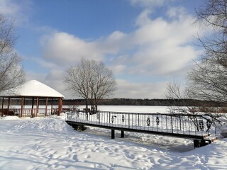 Landscape with snow. Winter landscape, bridge, gazebo. A clear winter day