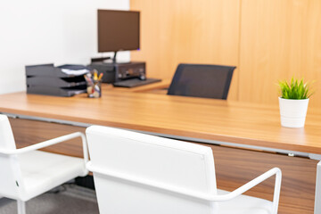 Mesa y sillas de despacho con ordenador y maceta