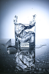  Water splash in glass with ice. Studio shoot.