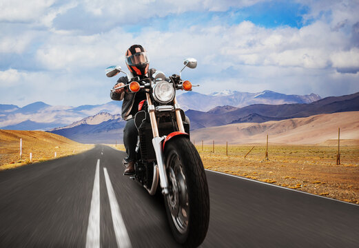a biker on a motorcycle rides on an asphalt road in the mountains © Кристина Пахомова