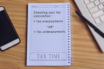 Text on notepad with laptop and smartphone on wooden table