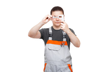 male mechanic in uniform holds bolt and vernier caliper in pocket with spanner wrench is taking...