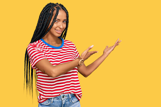 Beautiful hispanic woman wearing casual clothes inviting to enter smiling natural with open hand