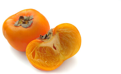 Ripe persimmon, orange Cut in half on a white background Taken at close range, corner, side