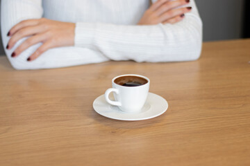 woman in turkish coffee and white sweater standing on wooden table