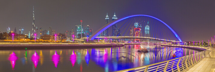 Dubai - The evening skyline with the arched bridge over the new Canal and Downtown.