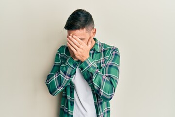Fototapeta premium Handsome man with beard wearing casual clothes with sad expression covering face with hands while crying. depression concept.