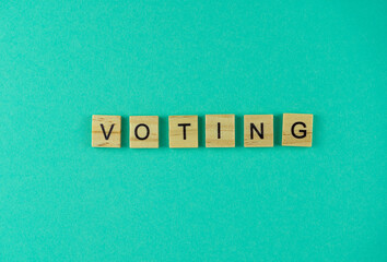 Word Voting. The phrase is laid out in wooden letters. Top view. Motivation. Blue background. Copy space