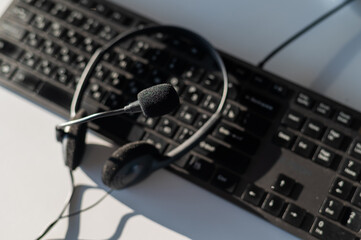 Headset with microphone on the computer keyboard. Call center operator's workplace