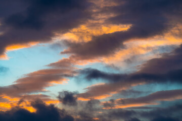 Fototapeta na wymiar Dramatic heaven: sunlit dark clouds in blue sky at sunset