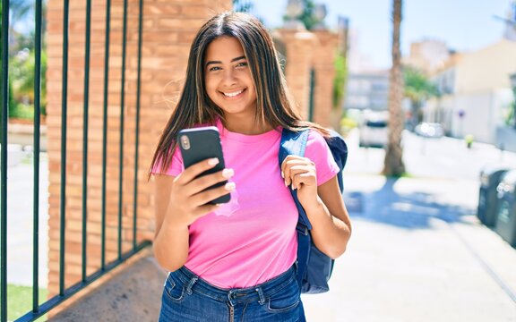 Young latin student girl smiling happy using smartphone at university campus.