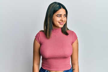 Young latin woman wearing casual clothes looking to side, relax profile pose with natural face and confident smile.