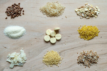 Assorted cereal grain porridge seeds set on a wooden background: buckwheat, rice, semolina, wheat, couscous, oatmeal