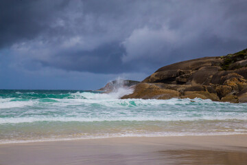 Fototapeta na wymiar Australian landscape in November with sandy beach, blue sky, rocks and sea.