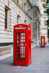 Old traditional red telephone booth on a street in the city of London