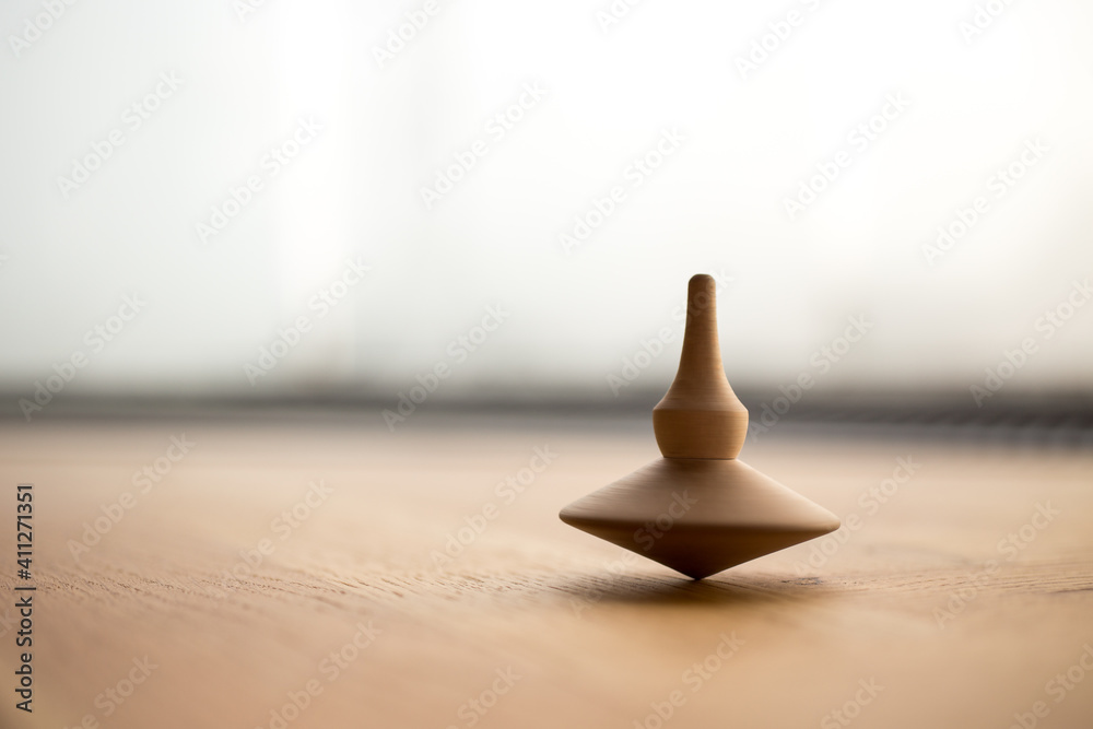 Wall mural wooden Spinning top in action on wooden flor, rotating totem in motion