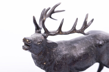 A roaring brass deer with large antlers