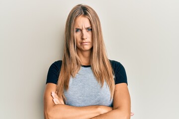 Young blonde woman wearing casual clothes skeptic and nervous, disapproving expression on face with crossed arms. negative person.