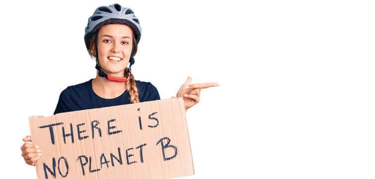 Beautiful caucasian woman holding there is no planet b banner smiling happy pointing with hand and finger to the side