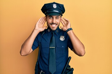 Handsome hispanic man wearing police uniform trying to hear both hands on ear gesture, curious for gossip. hearing problem, deaf