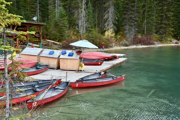 Obraz premium red canoes are tied to a dock waiting to be rented