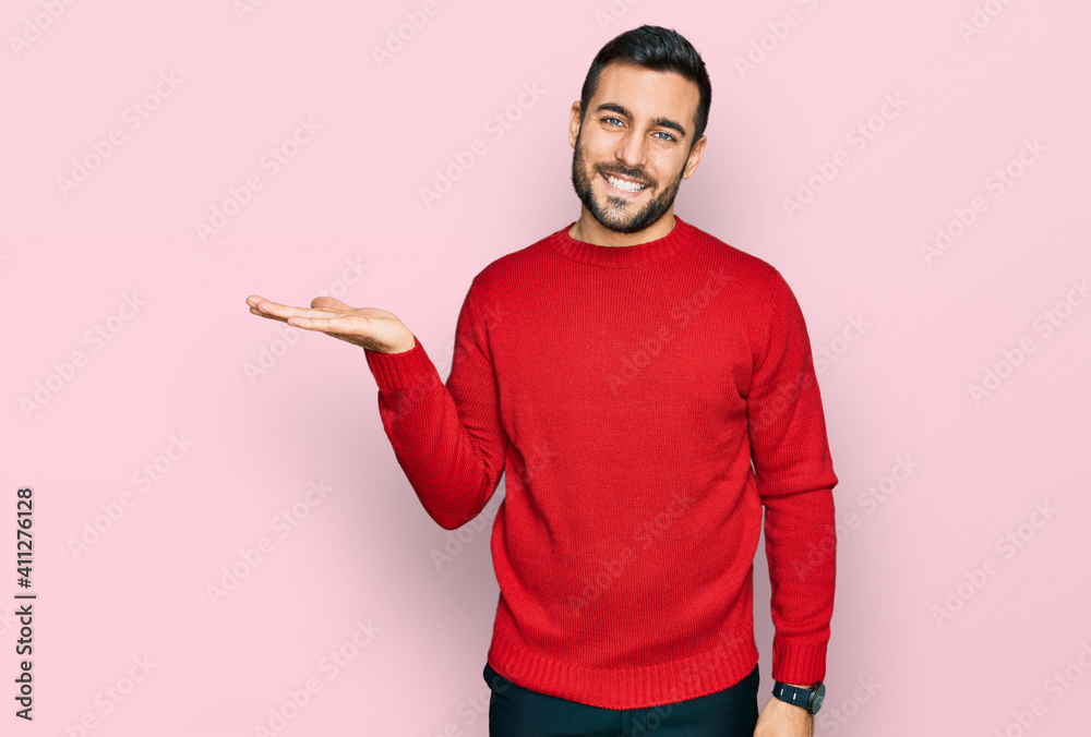 Poster young hispanic man wearing casual clothes smiling cheerful presenting and pointing with palm of hand