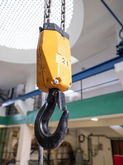 Industrial lifting crane hook and steel. Close up view of hook hanging on metal chain