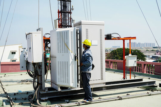 Electrical Control Cabinet, Engineer Standing In Front Of The Control Cabinet On The Rooftop. Technician Worker Repair Telecommunication.