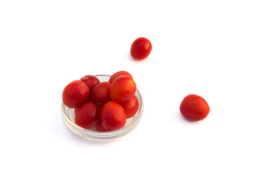 Group of red wild cherry plums in the glass vase isolated on the white background.