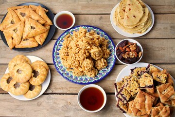 Traditional Tatar Cuisine On Wooden Table. Kystybyi, Echpochmak, Peremech, Chak Chak, Belesh, Tea In Piala, Dried Fruits And Nuts. Top View.