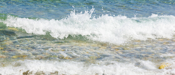 Sea wave and pebble. Summer vacation concept. Sea wave with foam incident on the coastal shingle. Travel concept